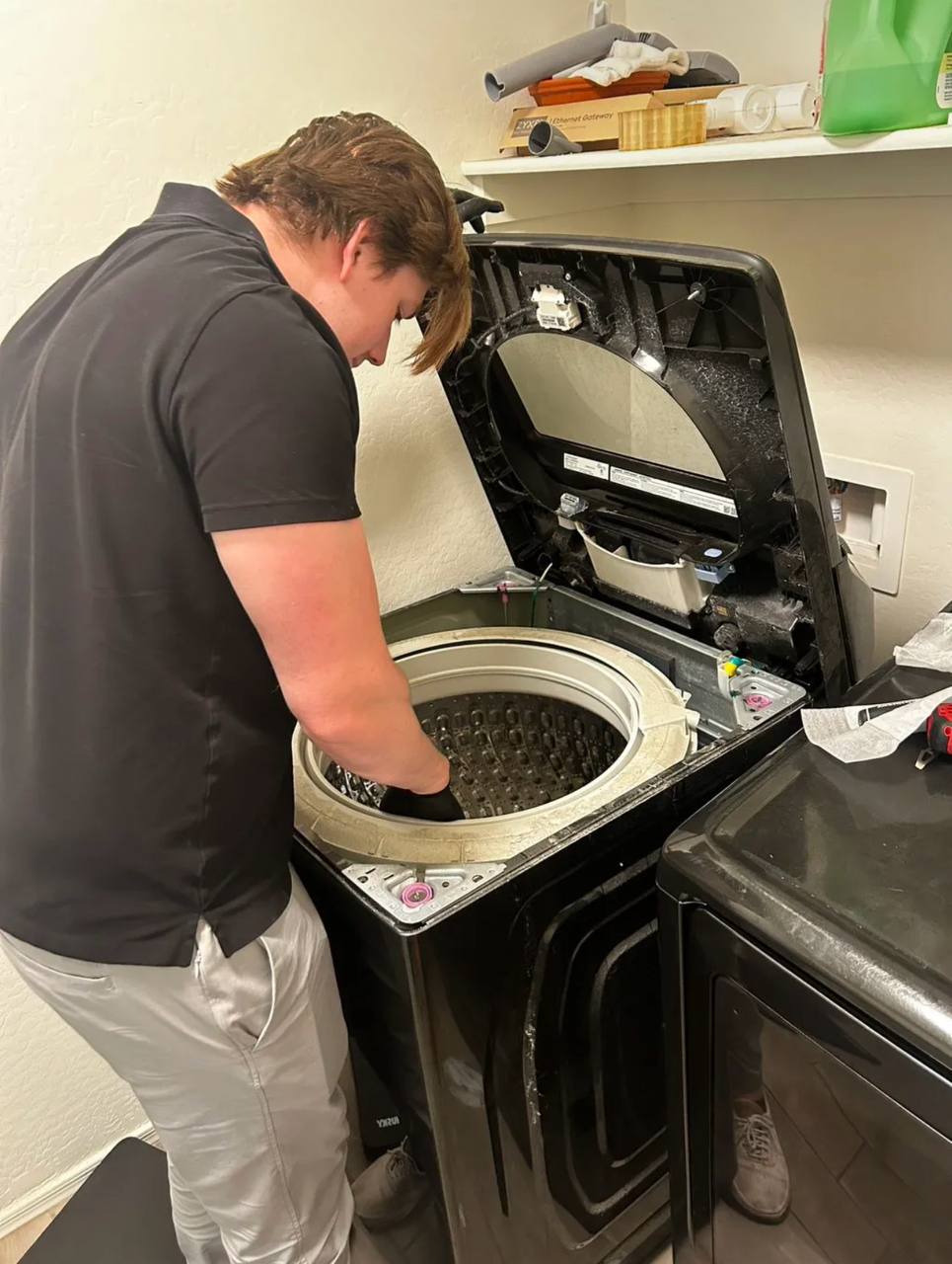 Technician repairing a top-load washing machine